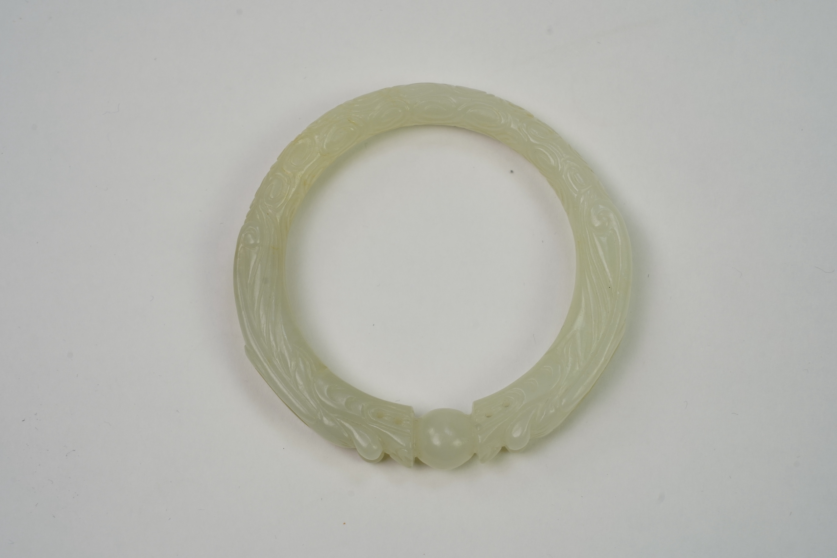 A Chinese pale celadon jade ’dragon’ bangle